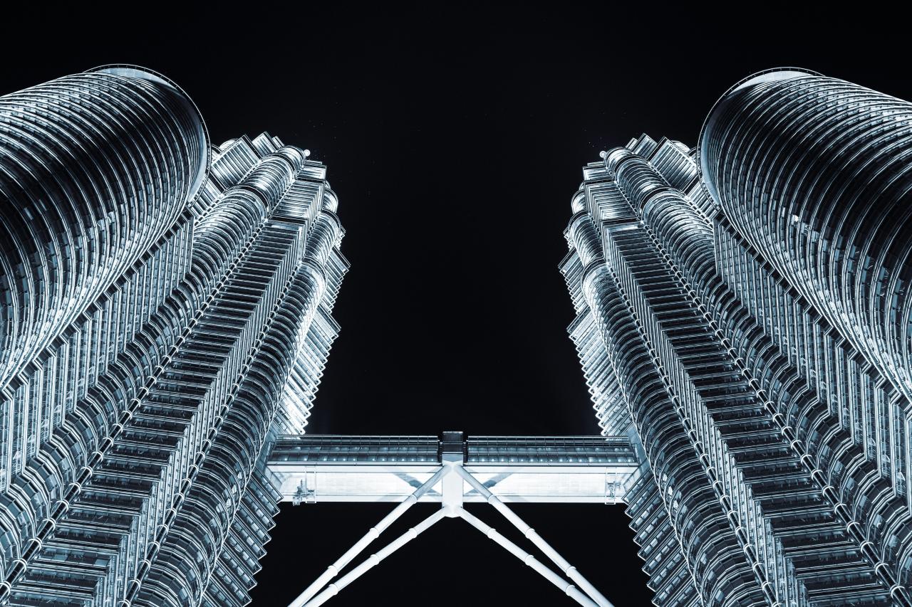 Petronas towers are illuminated at night.